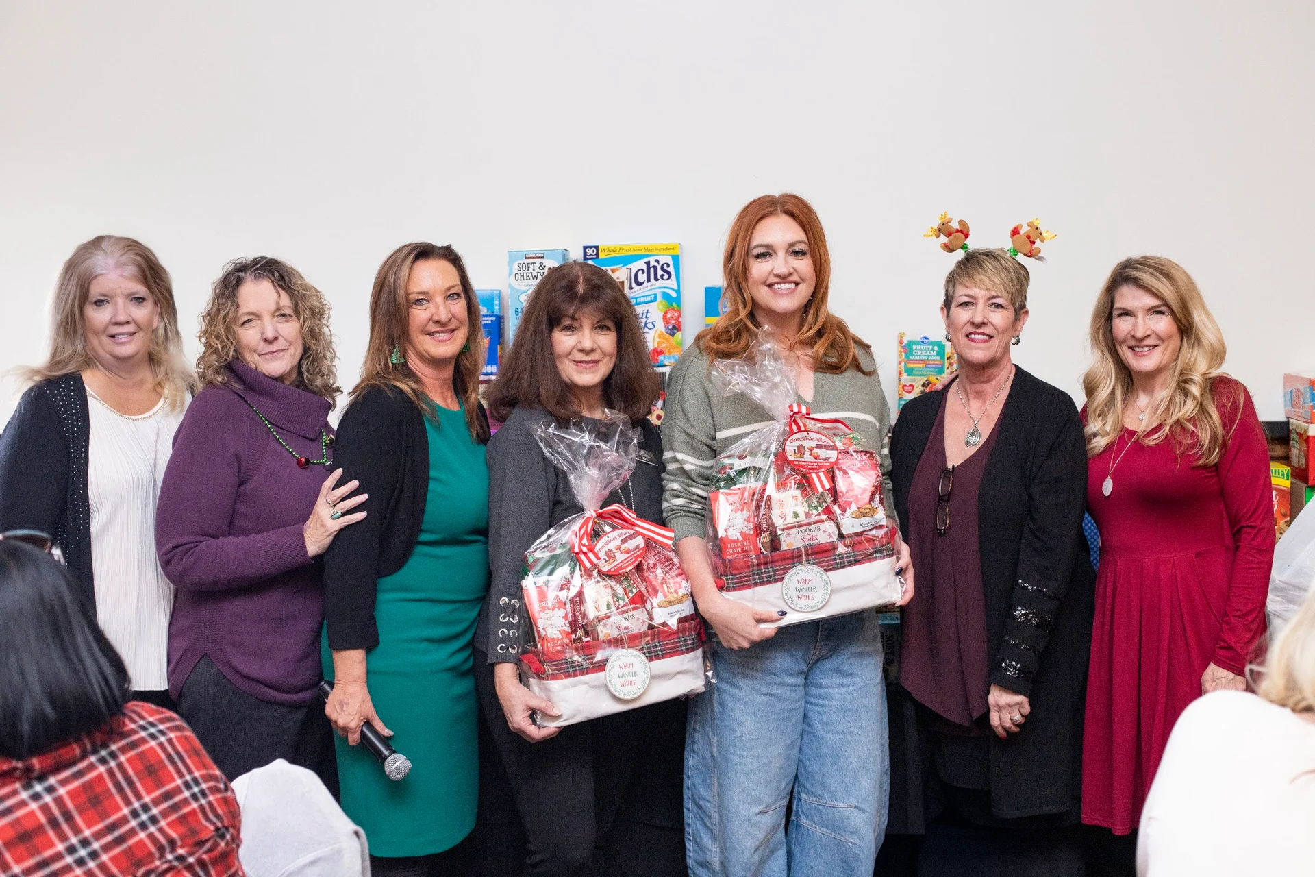 A group of women holding wrapped gifts at the 2025 event