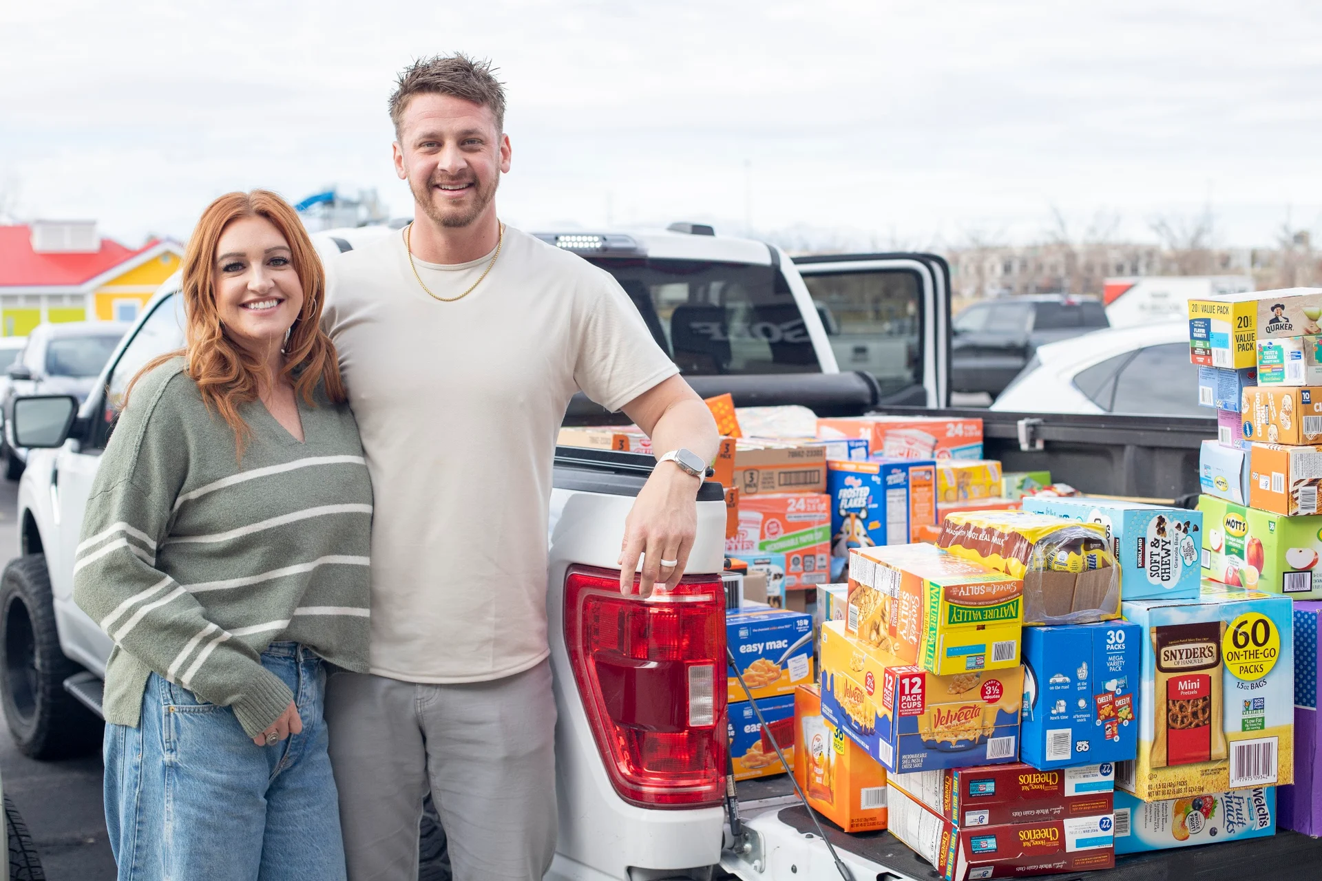Two people standing beside donated food outside the 2025 event