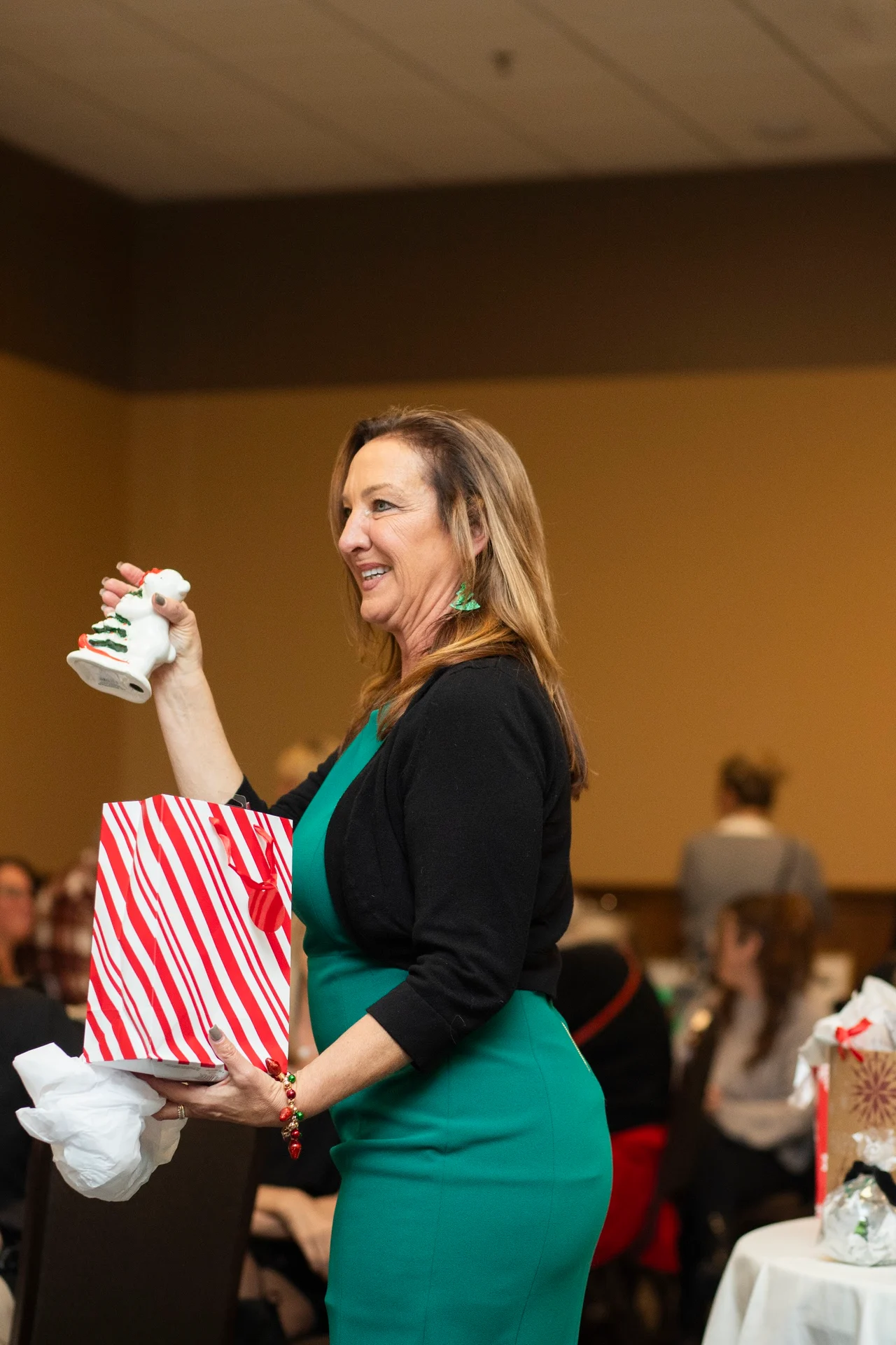 A woman holding an ornament beside a gift bag during the 2025 exchange